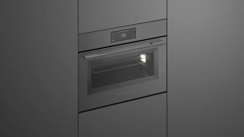 An angled view of the oven that's integrated into a grey wall An angled view of the oven that's integrated into a grey wall