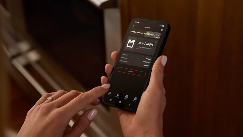 Person holding a smartphone using the smart appliance app to monitor Fisher & Paykel oven temperature Person holding a smartphone using the smart appliance app to monitor Fisher & Paykel oven temperature