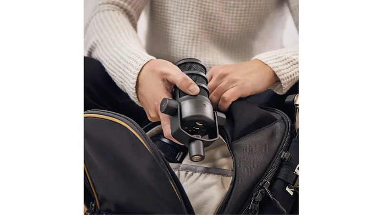 Close-up view showing a person packing the microphone into a bag Close-up view showing a person packing the microphone into a bag