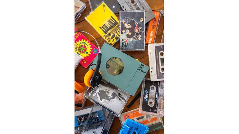 Blue We Are Rewind cassette player displayed among cassette tapes and music accessories Blue We Are Rewind cassette player displayed among cassette tapes and music accessories