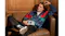 Person reclining on a leather chair while holding the We Are Rewind Kurt portable cassette player in blue Person reclining on a leather chair while holding the We Are Rewind Kurt portable cassette player in blue
