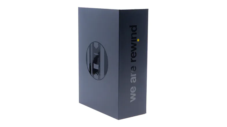 Angled side view of the We Are Rewind retail packaging showcasing branding and cassette window Angled side view of the We Are Rewind retail packaging showcasing branding and cassette window