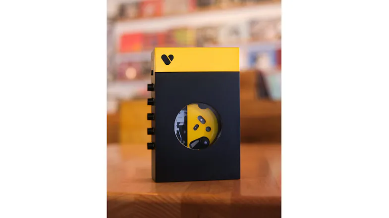 Front-facing lifestyle shot of the We Are Rewind Amy portable cassette player in black and yellow Front-facing lifestyle shot of the We Are Rewind Amy portable cassette player in black and yellow