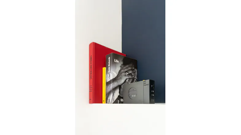 Partial view of the We Are Rewind Keith cassette player positioned on a shelf next to books Partial view of the We Are Rewind Keith cassette player positioned on a shelf next to books