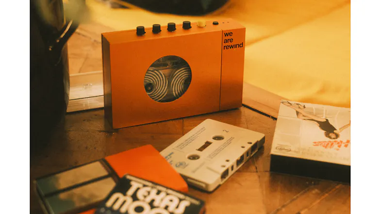 Orange cassette player displayed with cassette tapes and audio media in a retro-inspired tabletop setting Orange cassette player displayed with cassette tapes and audio media in a retro-inspired tabletop setting
