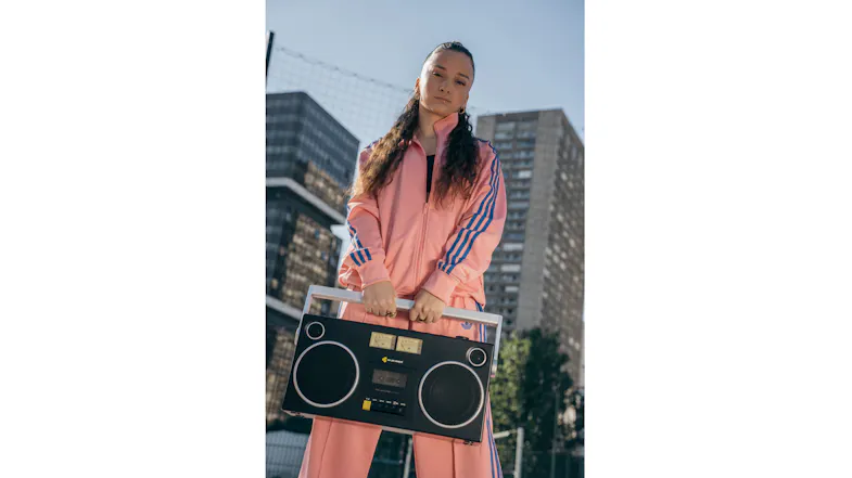 Lifestyle image of a person holding the black Bluetooth boombox cassette player in an outdoor city setting Lifestyle image of a person holding the black Bluetooth boombox cassette player in an outdoor city setting