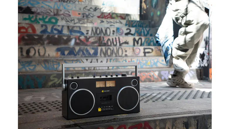 We Are Rewind Blaster Curtis portable boombox displayed outdoors near street art We Are Rewind Blaster Curtis portable boombox displayed outdoors near street art