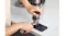 Person pressing down on a tamper with a funnel attached to a portafilter on a Ninja mat Person pressing down on a tamper with a funnel attached to a portafilter on a Ninja mat