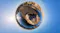 A 360-degree tiny planet aerial view showing a rocky desert landscape and body of water under a clear sky A 360-degree tiny planet aerial view showing a rocky desert landscape and body of water under a clear sky