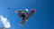 Low-angle view of a snowboarder jumping against a clear blue sky holding an extended action camera selfie stick Low-angle view of a snowboarder jumping against a clear blue sky holding an extended action camera selfie stick