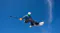Snowboarder mid-jump against a bright blue sky holding an extended selfie pole with a 360-action camera Snowboarder mid-jump against a bright blue sky holding an extended selfie pole with a 360-action camera