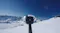 A close-up view of a 360-action camera mounted on a pole, overlooking a snowy mountain landscape A close-up view of a 360-action camera mounted on a pole, overlooking a snowy mountain landscape