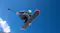 Low-angle view of a snowboarder catching air against a clear blue sky while filming with an action camera Low-angle view of a snowboarder catching air against a clear blue sky while filming with an action camera