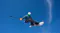Snowboarder floating through a clear blue sky during a jump while holding a 360 camera on a selfie stick Snowboarder floating through a clear blue sky during a jump while holding a 360 camera on a selfie stick