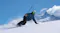 A snowboarder carving down a steep snow slope against alpine mountains, holding a 360-action camera A snowboarder carving down a steep snow slope against alpine mountains, holding a 360-action camera