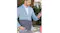 A man in a light blue blazer holds a charcoal grey Lenovo laptop sleeve while looking at his smartphone A man in a light blue blazer holds a charcoal grey Lenovo laptop sleeve while looking at his smartphone