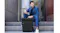 Man in blue suit sitting on steps with black Lenovo gaming backpack beside him on stone steps Man in blue suit sitting on steps with black Lenovo gaming backpack beside him on stone steps