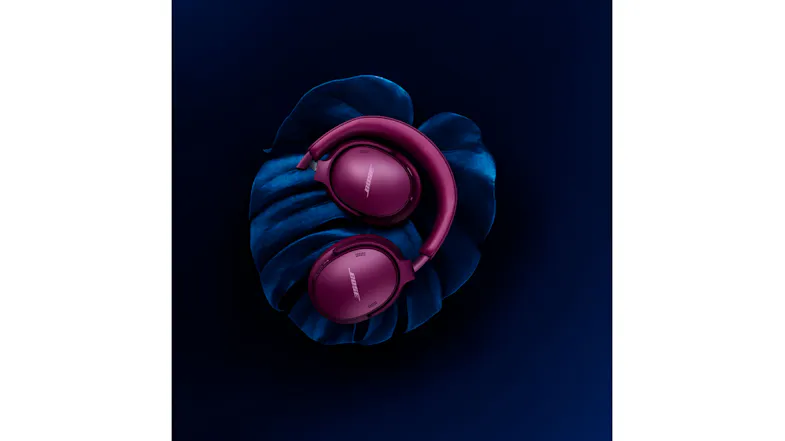 Magenta headphones resting on dark fabric highlighting vibrant colour Magenta headphones resting on dark fabric highlighting vibrant colour