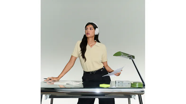 Woman in office featuring Bose QuietComfort headphones while holding paper Woman in office featuring Bose QuietComfort headphones while holding paper