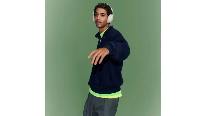 Man in blue jacket featuring Bose headphones over his ears Man in blue jacket featuring Bose headphones over his ears