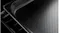 Close-up of a black perforated steam oven tray resting on a wire rack against a dark background Close-up of a black perforated steam oven tray resting on a wire rack against a dark background