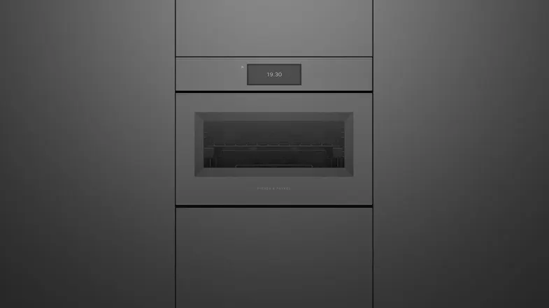 Front view of a minimalist, built-in matte grey Fisher & Paykel oven displaying the time 19:30 on its screen Front view of a minimalist, built-in matte grey Fisher & Paykel oven displaying the time 19:30 on its screen
