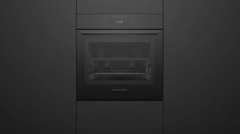 Front view of a black glass Fisher & Paykel wall oven integrated into cabinetry, displaying the time 19:30 Front view of a black glass Fisher & Paykel wall oven integrated into cabinetry, displaying the time 19:30