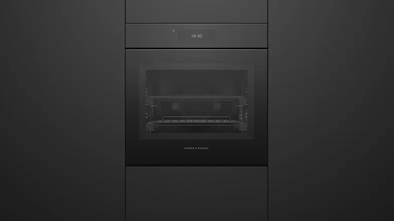 A sleek, built-in black Fisher & Paykel wall oven integrated into matte black cabinetry with a digital clock display A sleek, built-in black Fisher & Paykel wall oven integrated into matte black cabinetry with a digital clock display