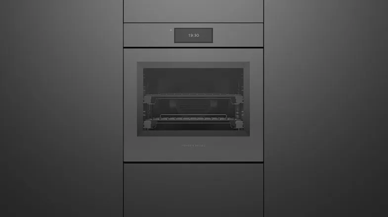 Sleek grey Fisher & Paykel wall oven integrated into matching dark cabinetry, featuring a small digital clock display Sleek grey Fisher & Paykel wall oven integrated into matching dark cabinetry, featuring a small digital clock display