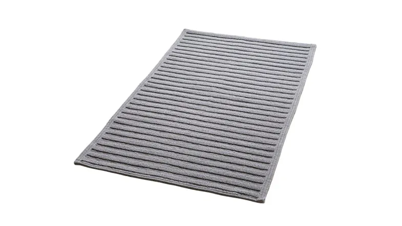 A ribbed grey Baksana Nova Luxury Bath Mat is placed beside a modern freestanding bathtub A ribbed grey Baksana Nova Luxury Bath Mat is placed beside a modern freestanding bathtub