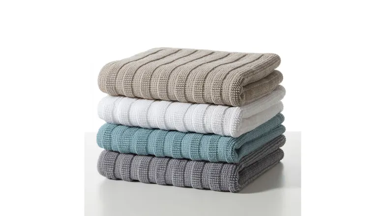 Four stacked ribbed Baksana Nova Luxury Bath Mats in Fog, Optic White, Baltic Green, and Magnetic Grey colour options Four stacked ribbed Baksana Nova Luxury Bath Mats in Fog, Optic White, Baltic Green, and Magnetic Grey colour options