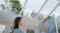 A lifestyle shot of a woman painting on a canvas while her robot window cleaner is cleaning the glass ceiling above A lifestyle shot of a woman painting on a canvas while her robot window cleaner is cleaning the glass ceiling above