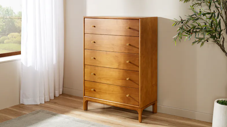 Five-drawer wooden chest with warm finish, brass-look handles and raised legs Five-drawer wooden chest with warm finish, brass-look handles and raised legs