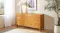 Six-drawer wooden dresser with warm finish, brass-look handles and raised legs Six-drawer wooden dresser with warm finish, brass-look handles and raised legs