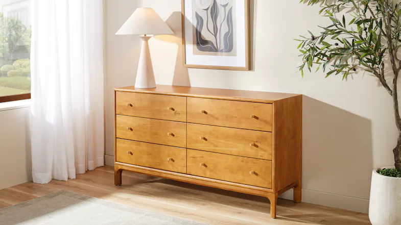 Six-drawer wooden dresser with warm finish, brass-look handles and raised legs Six-drawer wooden dresser with warm finish, brass-look handles and raised legs