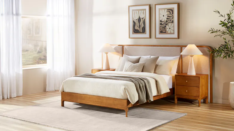 Wooden bed frame with integrated extended upholstered headboard, matching bedside tables and neutral bedding Wooden bed frame with integrated extended upholstered headboard, matching bedside tables and neutral bedding