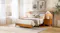 Wooden bed frame with integrated extended upholstered headboard, matching bedside tables and neutral bedding Wooden bed frame with integrated extended upholstered headboard, matching bedside tables and neutral bedding