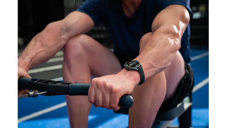 Person exercising on rowing equipment while wearing the smartwatch, showcasing activity tracking Person exercising on rowing equipment while wearing the smartwatch, showcasing activity tracking