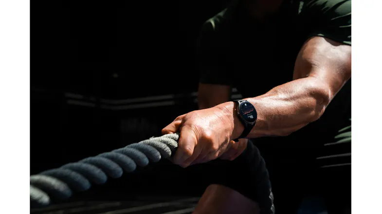 Detailed view of a wrist wearing a smartwatch while gripping battle ropes Detailed view of a wrist wearing a smartwatch while gripping battle ropes