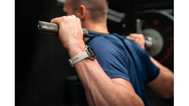 Person performing a strength training exercise while wearing the smartwatch with a grey band Person performing a strength training exercise while wearing the smartwatch with a grey band