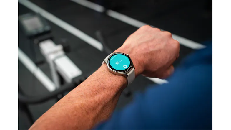 Close-up of the Ryze Flex (Gen 2) SmartWatch with a grey case and grey band worn during a rowing workout Close-up of the Ryze Flex (Gen 2) SmartWatch with a grey case and grey band worn during a rowing workout