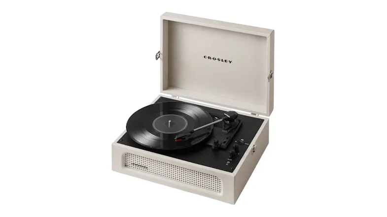 Cream suitcase-style record player with open lid and black vinyl record Cream suitcase-style record player with open lid and black vinyl record