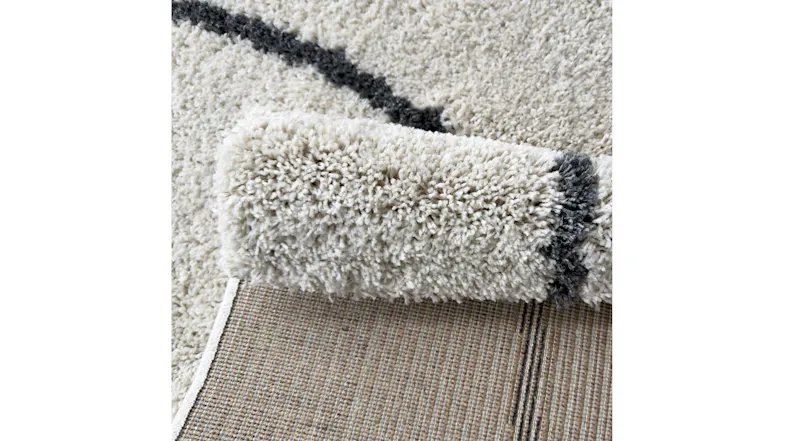 Side view of rug edge with visible thickness, border detail, and precise stitching Side view of rug edge with visible thickness, border detail, and precise stitching