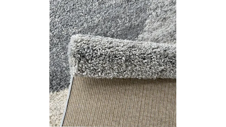 Side view of rug edge with decorative border and precise stitching detail Side view of rug edge with decorative border and precise stitching detail