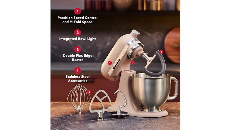 Feathered Pink KitchenAid Artisan Plus Stand Mixer with a stainless steel bowl and attachments on a kitchen countertop Feathered Pink KitchenAid Artisan Plus Stand Mixer with a stainless steel bowl and attachments on a kitchen countertop