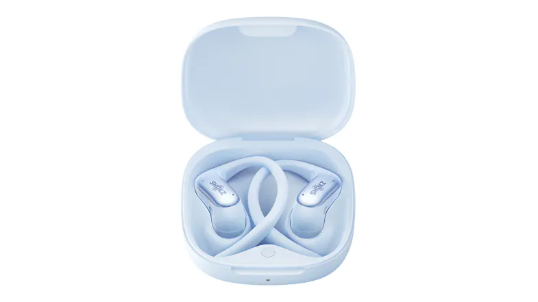 Top-down view of ice blue Shokz open-ear wireless earbuds in an open charging case with wraparound ear hooks Top-down view of ice blue Shokz open-ear wireless earbuds in an open charging case with wraparound ear hooks