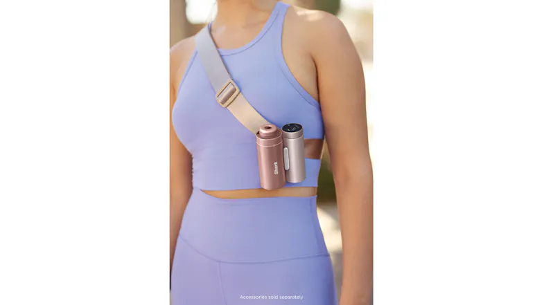 Rose gold and pink Shark ChillPill devices clipped to a tan crossbody strap worn with purple activewear Rose gold and pink Shark ChillPill devices clipped to a tan crossbody strap worn with purple activewear