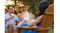 Rose gold Shark ChillPill device on an Adirondack chair armrest, spraying mist toward a person in a blue dress Rose gold Shark ChillPill device on an Adirondack chair armrest, spraying mist toward a person in a blue dress