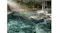 Robotic pool skimmer operating on a swimming pool surface near the pool edge Robotic pool skimmer operating on a swimming pool surface near the pool edge