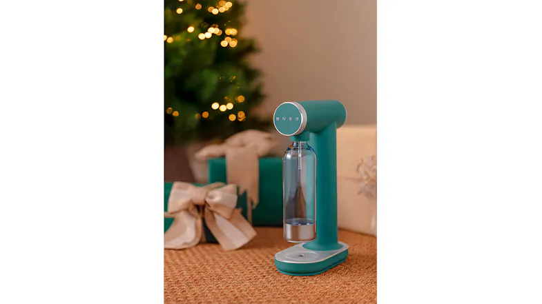 Side-angle lifestyle view of the Sparkling Water Maker in matte emerald green, positioned on a wooden table Side-angle lifestyle view of the Sparkling Water Maker in matte emerald green, positioned on a wooden table